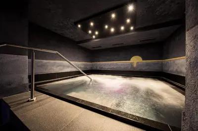 a hot tub in a dark room with lights at Hotel Alpenflora in Castelrotto
