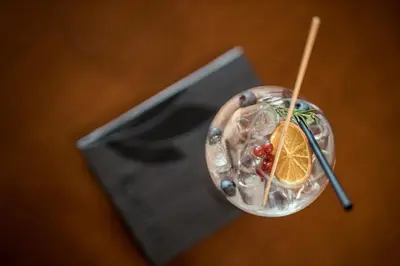 a drink with an orange and berries on a table at Hotel Alpenflora in Castelrotto