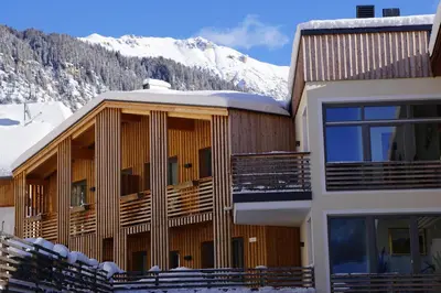a building with snow covered mountains in the background at La Palsa in La Valle