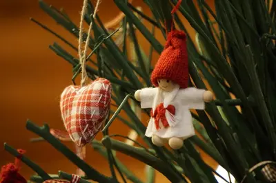 a toy doll and a heart ornament hanging from a christmas tree at La Palsa in La Valle