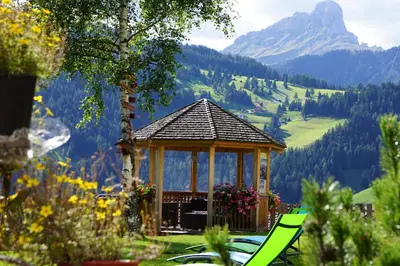 a gazebo with a table and chairs in a garden at La Palsa in La Valle