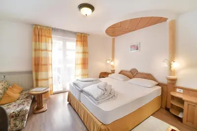 a hotel room with a bed and a couch at Albergo al Cervo - Gasthof zum Hirschen in Lagundo