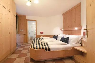 a bedroom with a large bed in a room at Alpin-Residence Amadeus in Siusi