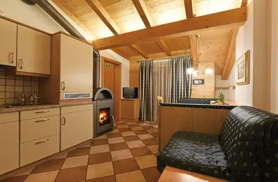 a kitchen with a living room with a fireplace at Alpin-Residence Amadeus in Siusi