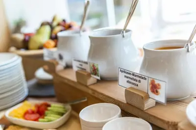 a table with cups of coffee and a bowl of fruit at Garni la Bercia in Selva di Val Gardena