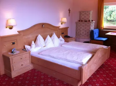 a bedroom with a large wooden bed in a room at Garni la Bercia in Selva di Val Gardena
