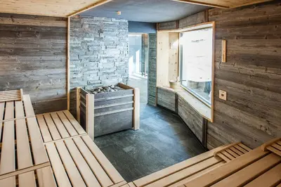 a room with two beds and a stone wall at Das Mondschein in Obereggen