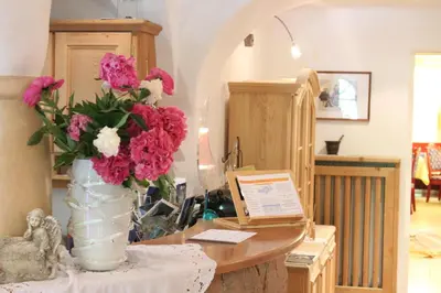 a vase filled with pink and white flowers on a table at Das Mondschein in Obereggen