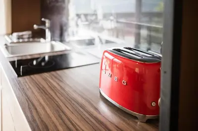 a red toaster sitting on top of a kitchen counter at Pension Haus Tirol in Laion