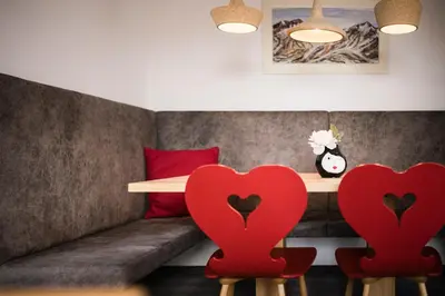 a living room with red chairs and a couch at Pension Haus Tirol in Laion