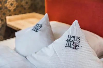 two white pillows with the words hicks inc on them at Pension Haus Tirol in Laion