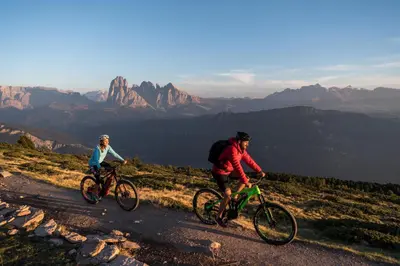 two people riding bikes on a mountain road at Pension Haus Tirol in Laion
