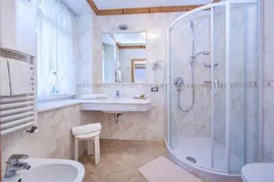 a bathroom with a shower and a sink at Hotel Corona Krone in Selva di Val Gardena