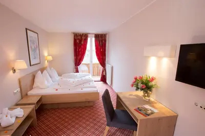 a hotel room with a bed and a table at Hotel Stamserhof in Andrian