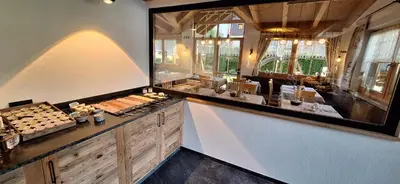 a restaurant with wooden walls and tables and chairs at Garni Hotel Residence Diamant in San Vigilio Di Marebbe