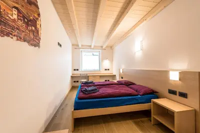 a dining room with a table with a bottle of wine at Attico Elbetina in Campitello di Fassa