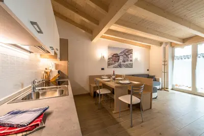 a balcony with a view of a town and mountains at Attico Elbetina in Campitello di Fassa