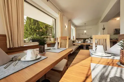 a dining room with a table and chairs and a window at Arya Alpine Lodge in Selva di Val Gardena