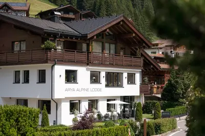 a large white building with a black roof at Arya Alpine Lodge in Selva di Val Gardena