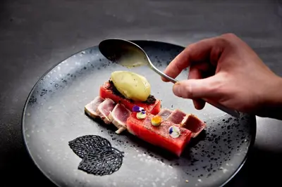 a person eating a piece of food on a plate at Hotel Das Sonnenparadies in Schenna