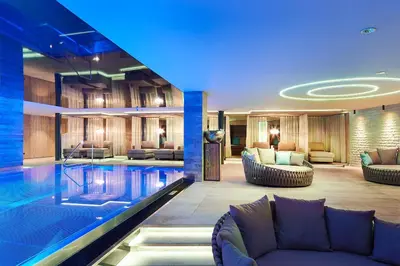 a hotel lobby with a pool and furniture at Hotel Das Sonnenparadies in Schenna