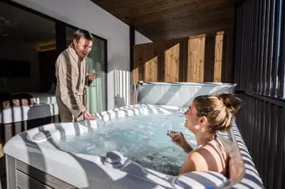 a man and a woman in a hot tub at K1 Mountain Chalet - Luxury Apartements in Brunico