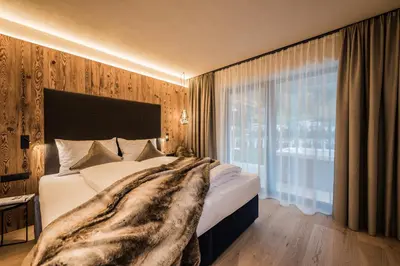a bedroom with a large bed with a large window at K1 Mountain Chalet - Luxury Apartements in Brunico