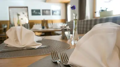 a table with napkins and utensils on top of it at Hotel Sterzinger Moos in Vipiteno