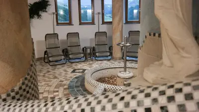 a group of chairs sitting in a room with a tub at Hotel Sterzinger Moos in Vipiteno