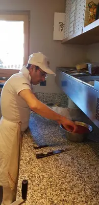 a man standing in a kitchen preparing food at Gasthof Toni in Castelrotto