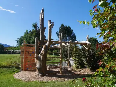 a tree stump swing in a garden at Baumgartnerhof in Naz-Sciaves