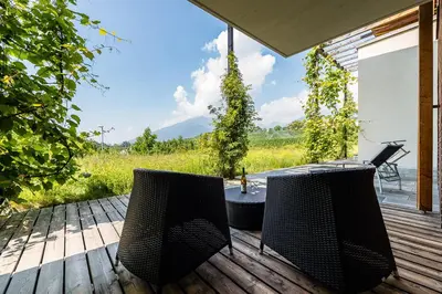 two chairs and a table on a wooden deck at Baumgartnerhof in Naz-Sciaves