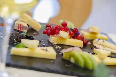 a plate of cheese and fruit on a table at Hotel Ramon in Campitello di Fassa