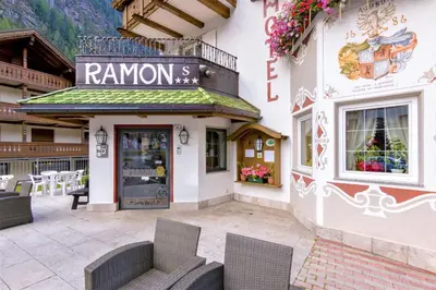 a restaurant with chairs in front of a building at Hotel Ramon in Campitello di Fassa