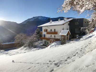 a house on top of a snow covered hill at Apartments Haus Gabi in Laion