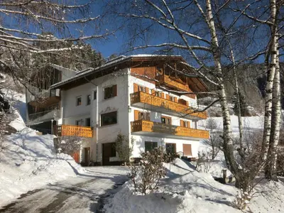 a building with a balcony in the snow at Apartments Haus Gabi in Laion