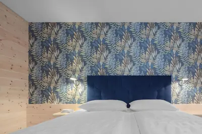 a bedroom with a bed with a blue and gold wallpaper at Apartments Haus Gabi in Laion