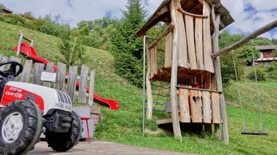 a toy tractor parked next to a wooden play structure at Apartments Haus Gabi in Laion