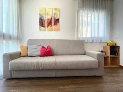 a living room with a couch with two red pillows at Ciasa de Zeno in La Valle