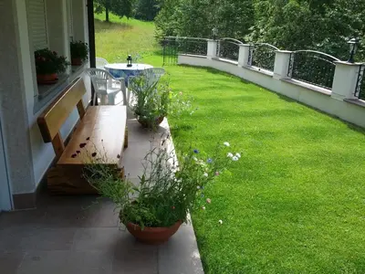 a porch with a bench and a table with plants at Villa Otto in Santa Cristina in Val Gardena