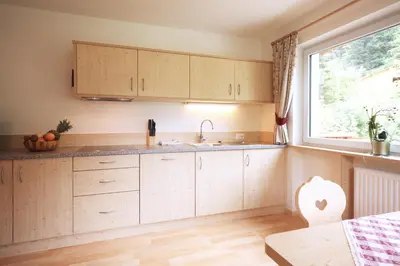 a kitchen with wooden cabinets and a window at Villa Otto in Santa Cristina in Val Gardena
