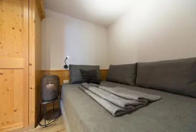a couch with a blanket on it in a room at Eden Apartments in Siusi