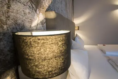 a hotel room with a bed and a wall at Eden Apartments in Siusi