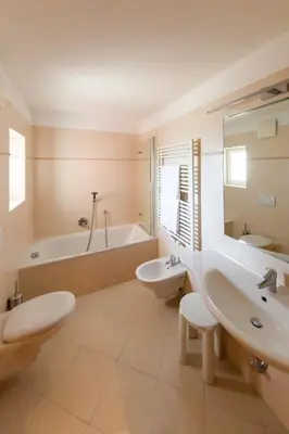 a bathroom with two sinks and a tub and a toilet at Eden Apartments in Siusi
