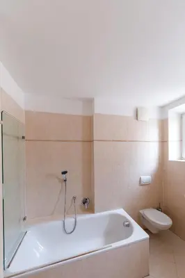 a bathroom with a white tub and a toilet at Eden Apartments in Siusi