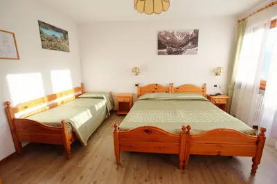 two twin beds in a bedroom with wooden floors at Hotel Des Alpes in Cortina dʼAmpezzo