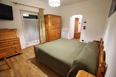a bedroom with a bed and a dresser and a television at Hotel Des Alpes in Cortina dʼAmpezzo