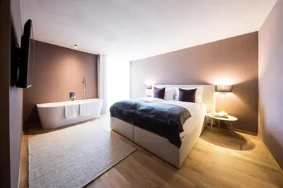 a bedroom with a large bed and a bath tub at Lamondis in Castelrotto