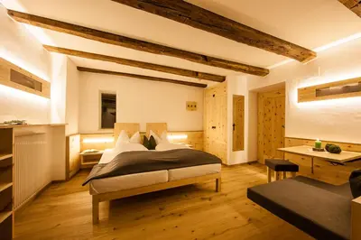 a bedroom with a large bed and a table at Hotel Restaurant Waldbichl in Verano