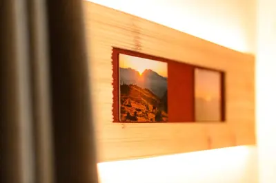 a mirror on a wall with a picture of a mountain at Hotel Restaurant Waldbichl in Verano